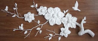 Stucco molding made of plaster with lighting in the form of a branch with flowers. The photo shows a test assembly of the lamp parts. 