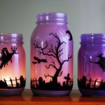 Painted glass jars with burning candles inside
